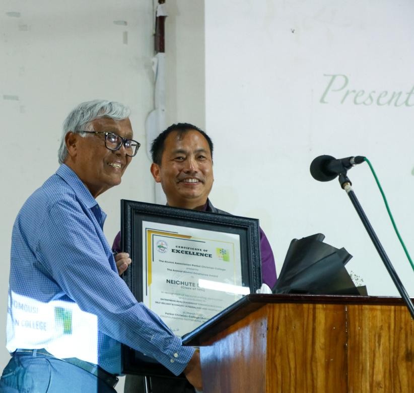 Neichute Doulo, the Founder & CEO of Entrepreneurs Associates receives the 2nd Patkai Christian College (Autonomous) Annual Alumni Excellence Award from Rev Dr Tuisem A Shishak, the college founder and Principal Emeritus, on March 25. (Morung Photo)